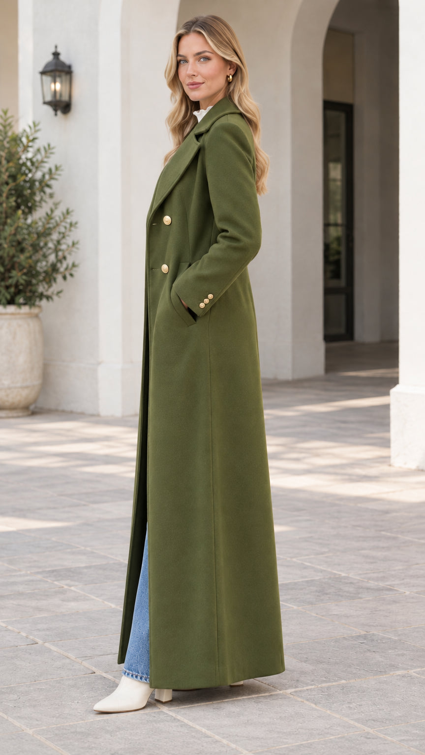 Side profile view of woman wearing the olive green double-breasted tailored maxi coat
