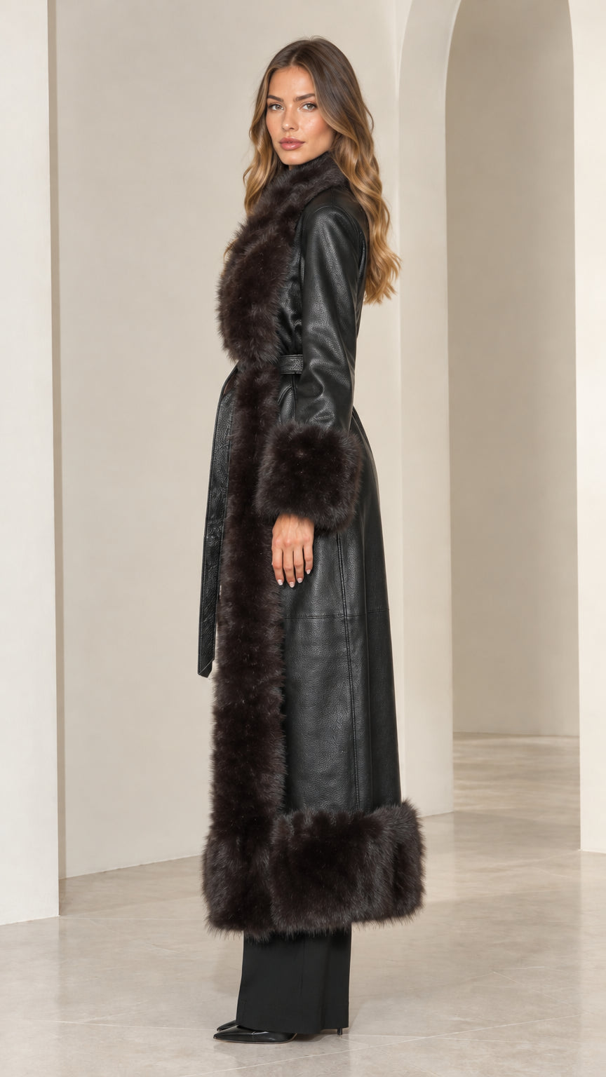 Side profile of black belted faux leather maxi coat with faux fur accents