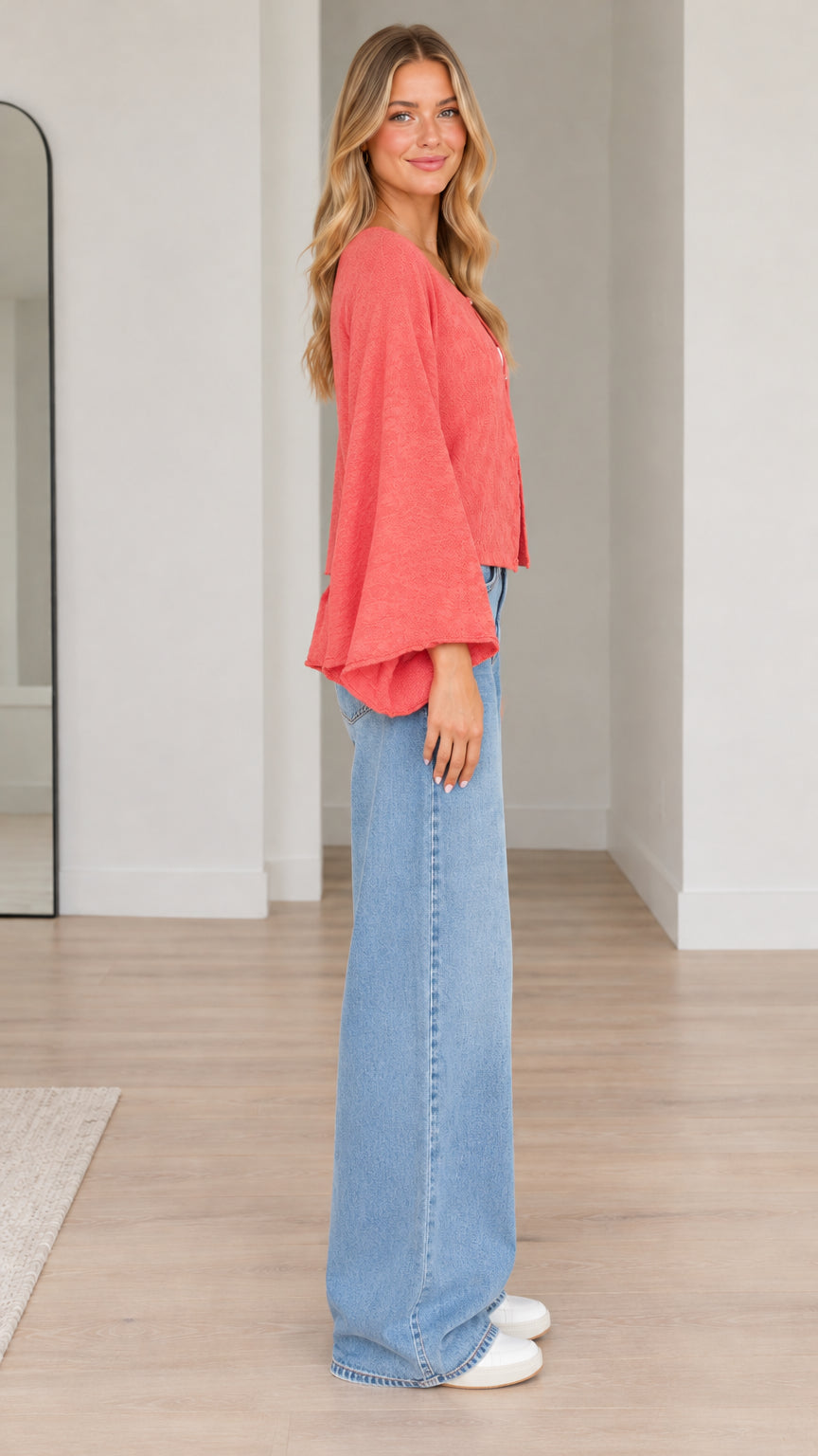 Side profile of model wearing coral bell sleeve cardigan
