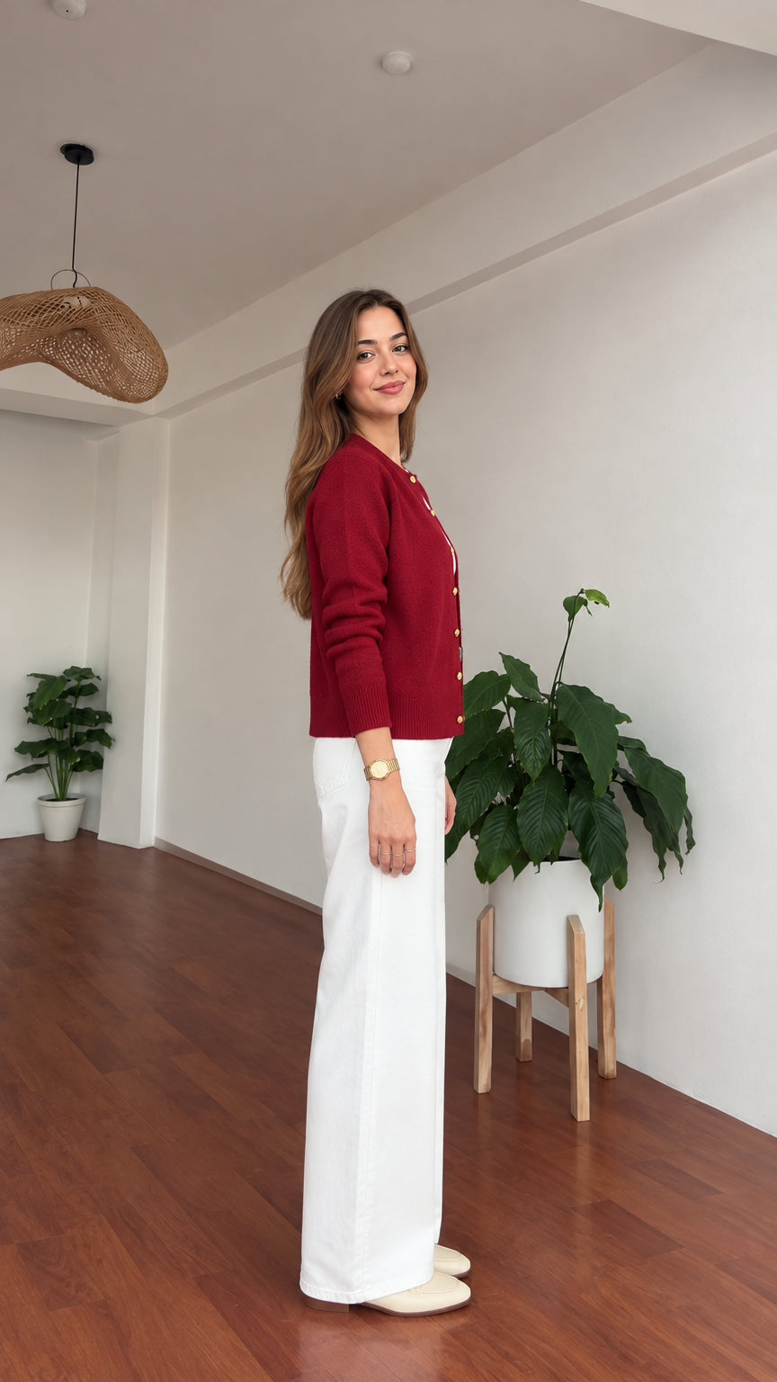 Side profile of model in burgundy textured knit cardigan paired with wide-leg pants