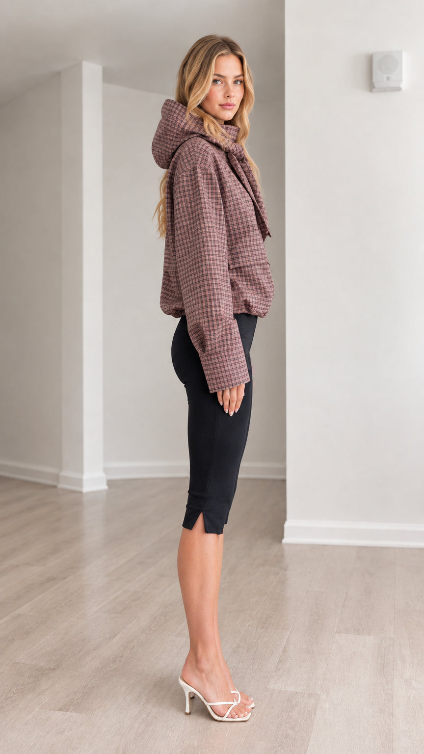 Side profile view of model wearing dusty rose plaid hooded jacket showing hood shape and gathered hem