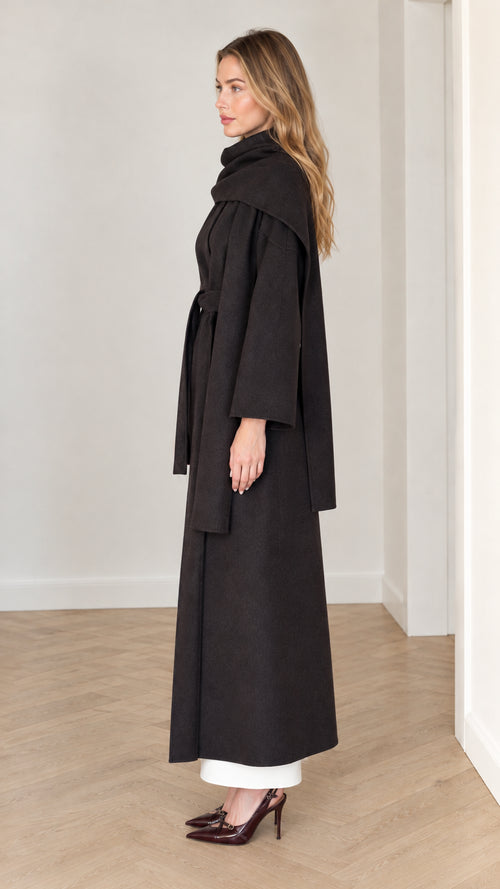 Side view of model wearing black scarf collar maxi coat with tied waist