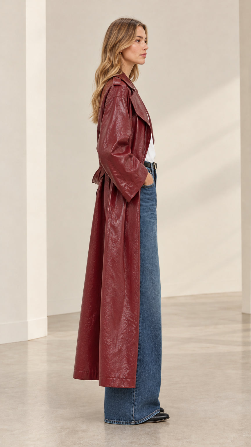 Side profile view of burgundy crinkled faux leather maxi trench coat