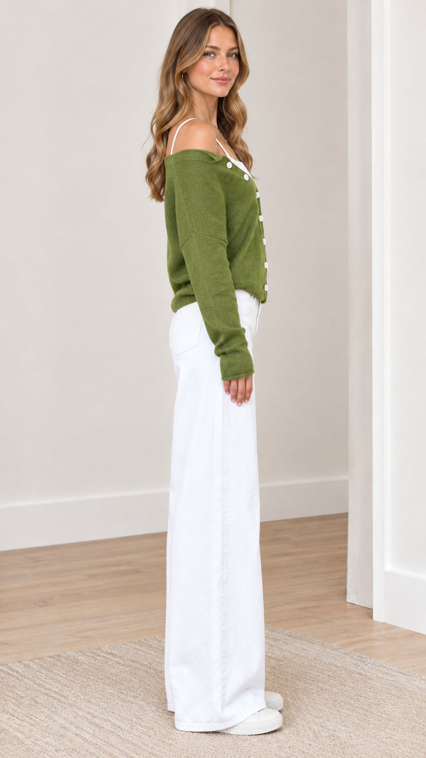 Side profile of woman wearing green off-shoulder buttoned knit sweater