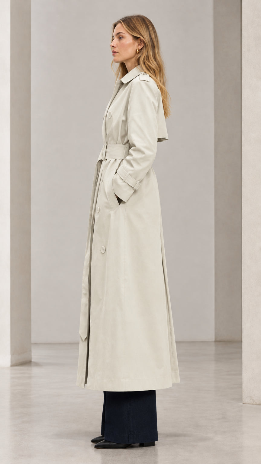 Side profile view of woman wearing Light Beige long belted trench coat