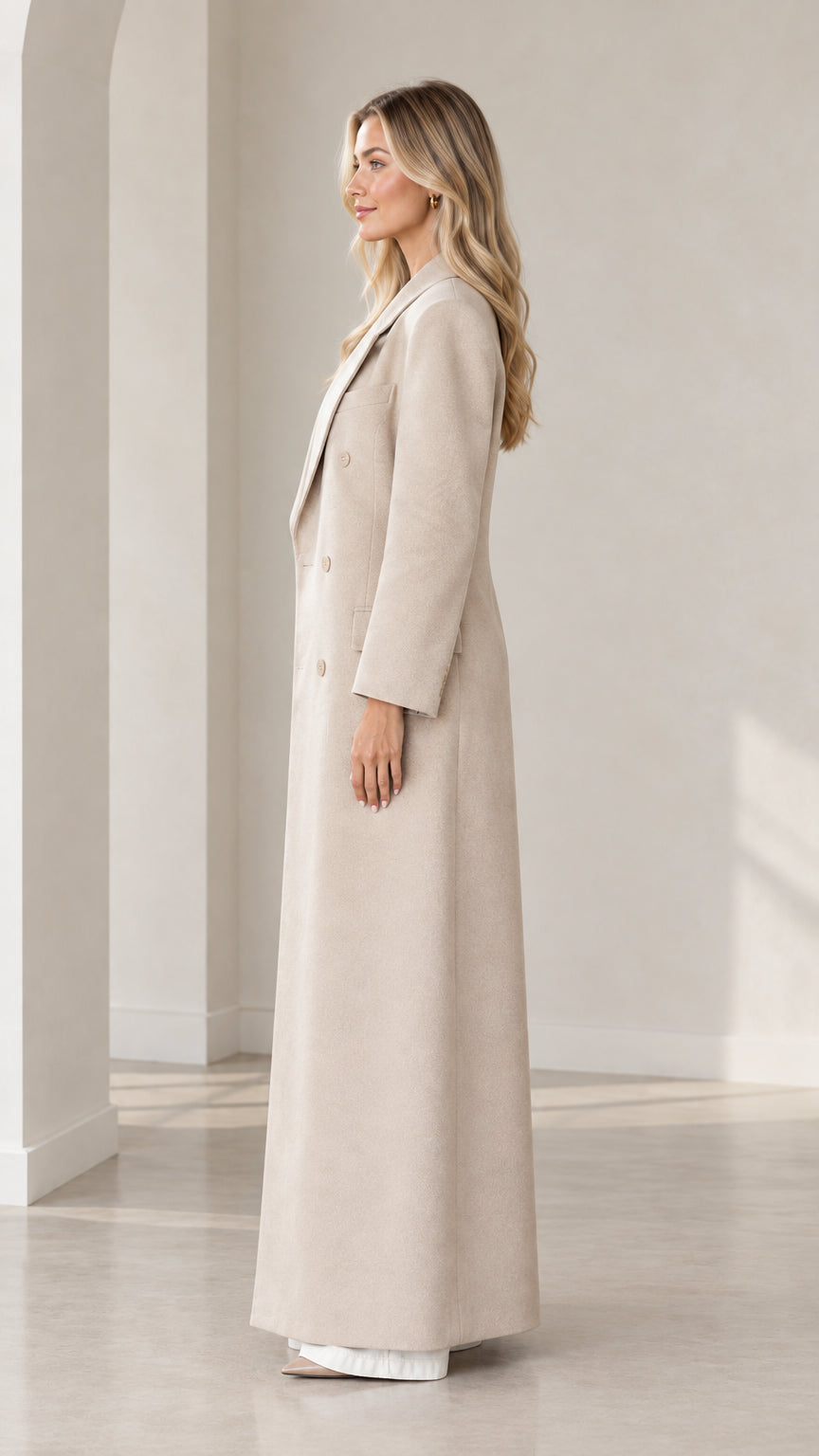 Side profile view of beige tailored maxi overcoat