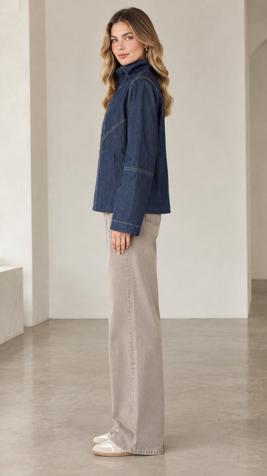 Side profile of model wearing dark blue high collar denim jacket
