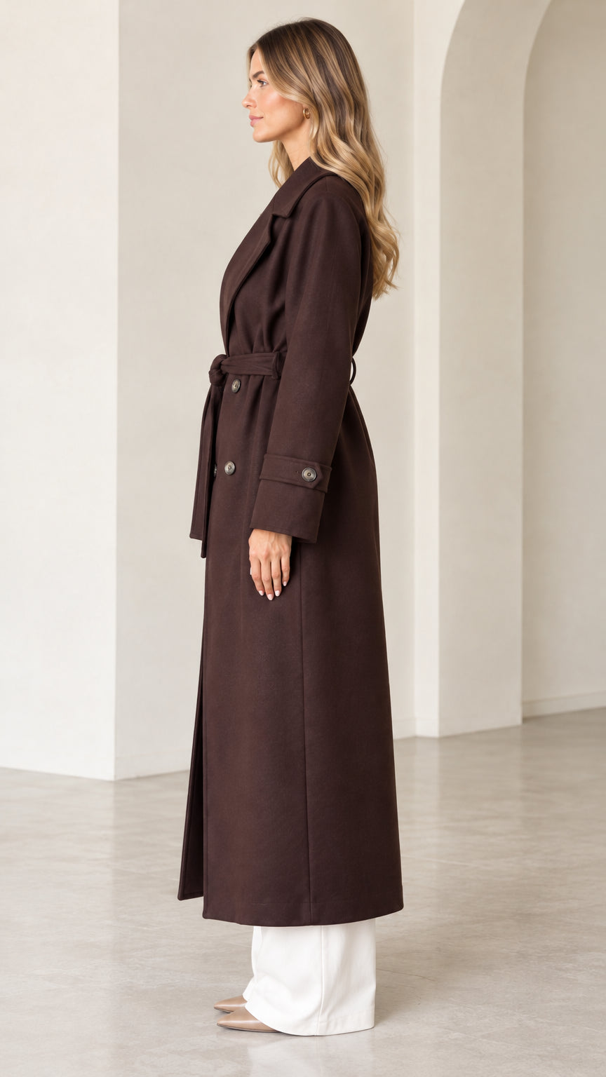 Side profile view of dark brown maxi trench coat with tie belt