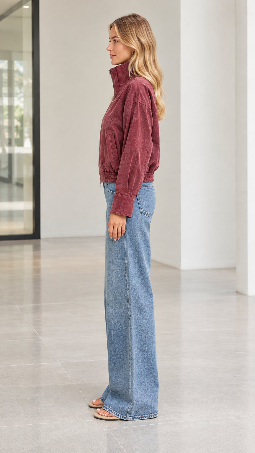 Side profile view of woman wearing burgundy corduroy zip-up jacket