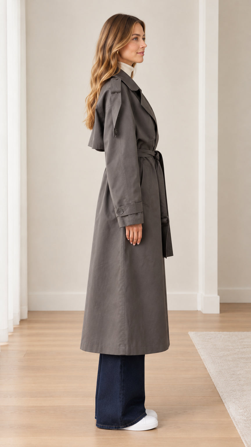 Side profile of model wearing dark grey long trench coat