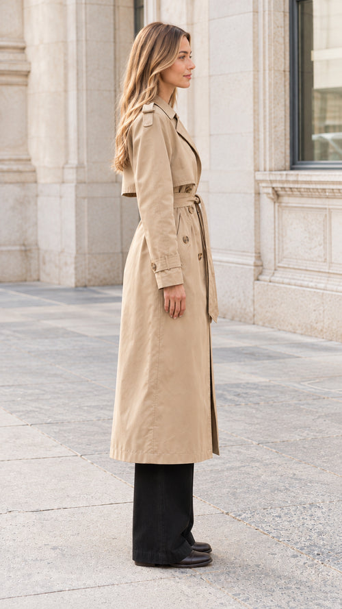 Side profile view of a woman wearing a beige long belted trench coat