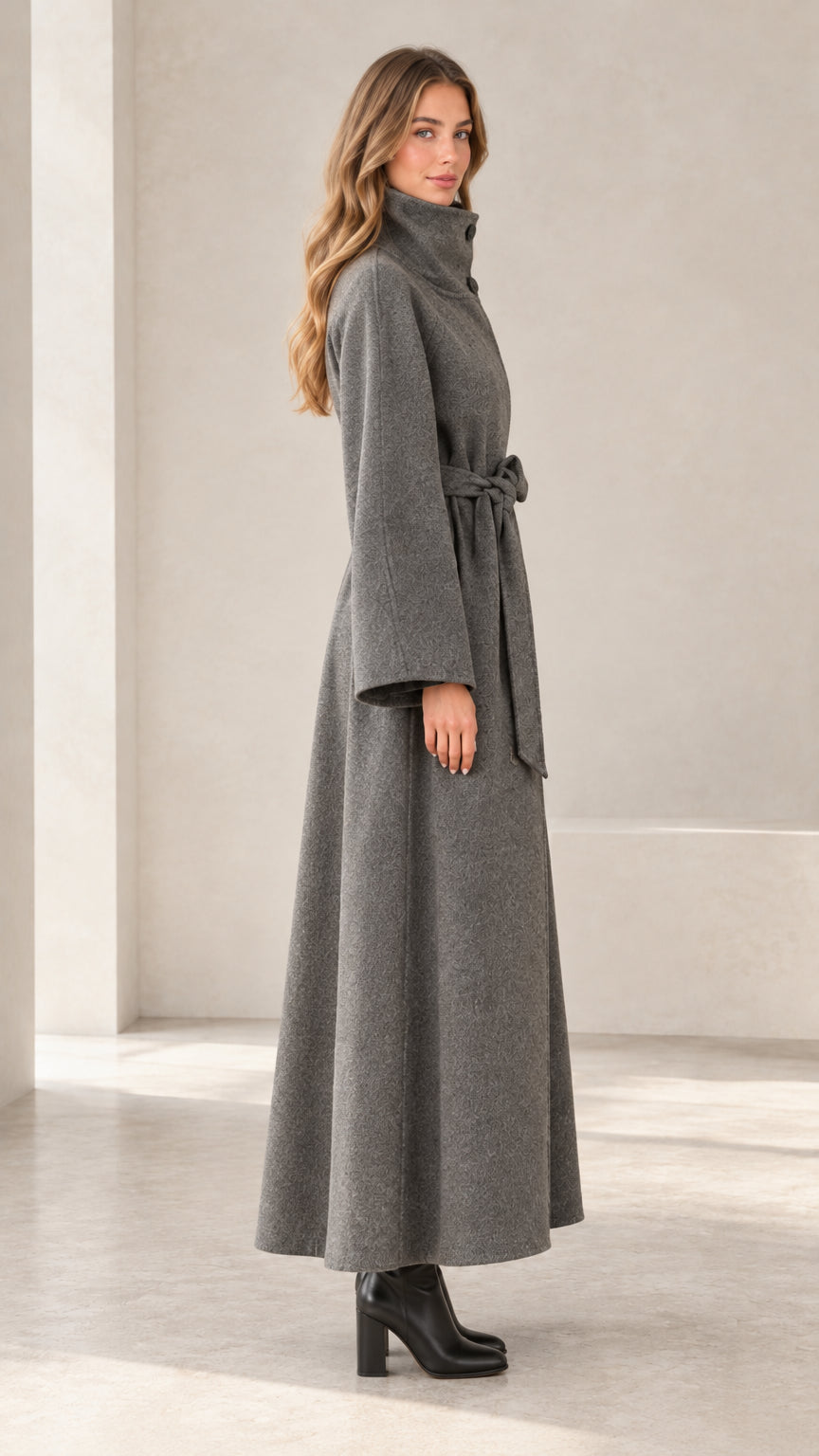 Side profile view of women's charcoal grey long overcoat showing sweeping hemline