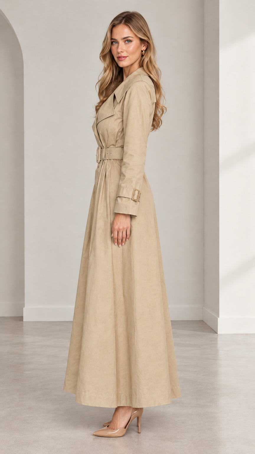 Side profile view of women's beige maxi trench coat showing flowing ankle-length hem