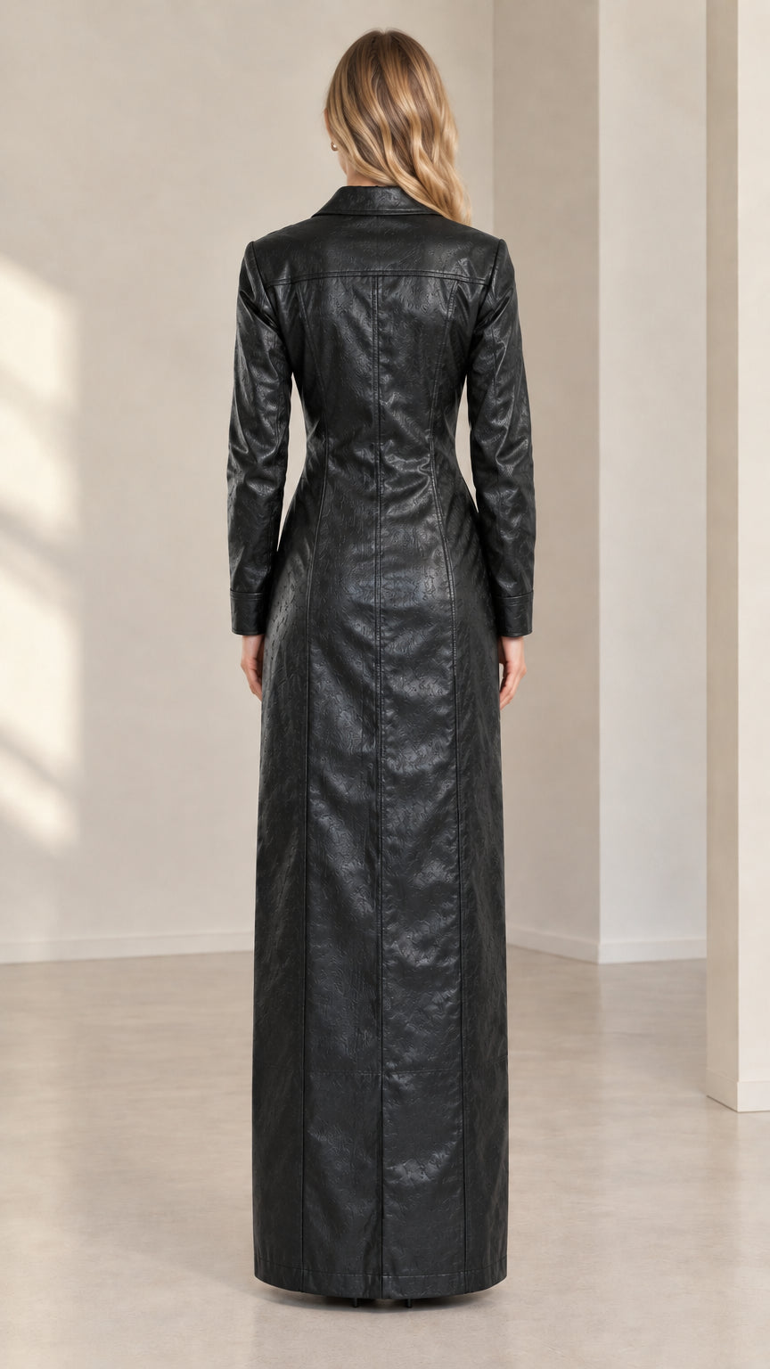 Back view of model wearing floor-length black faux leather shirt dress with center seam detail