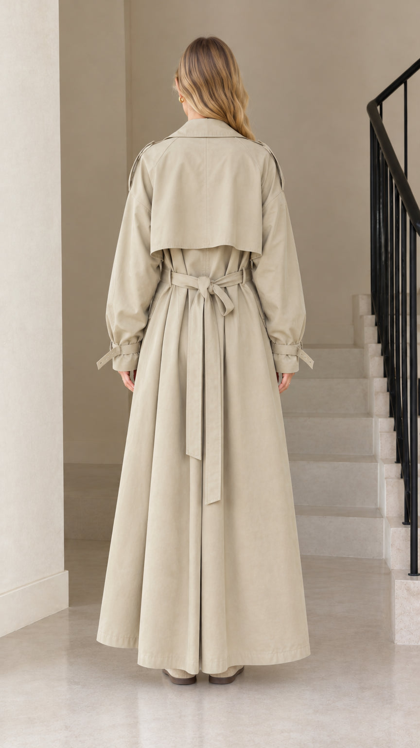 Back view of model wearing the Khaki maxi belted trench coat highlighting the storm flap