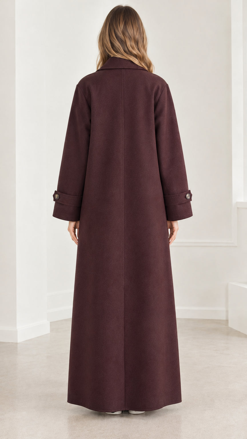 Back view of model showcasing the long tailored silhouette of the burgundy overcoat