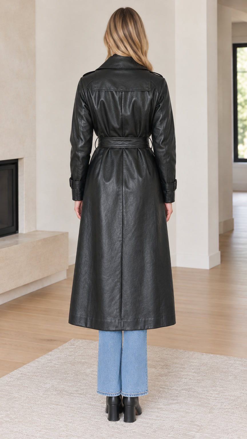 Back view of woman wearing long black faux leather trench coat showing back yoke and hem