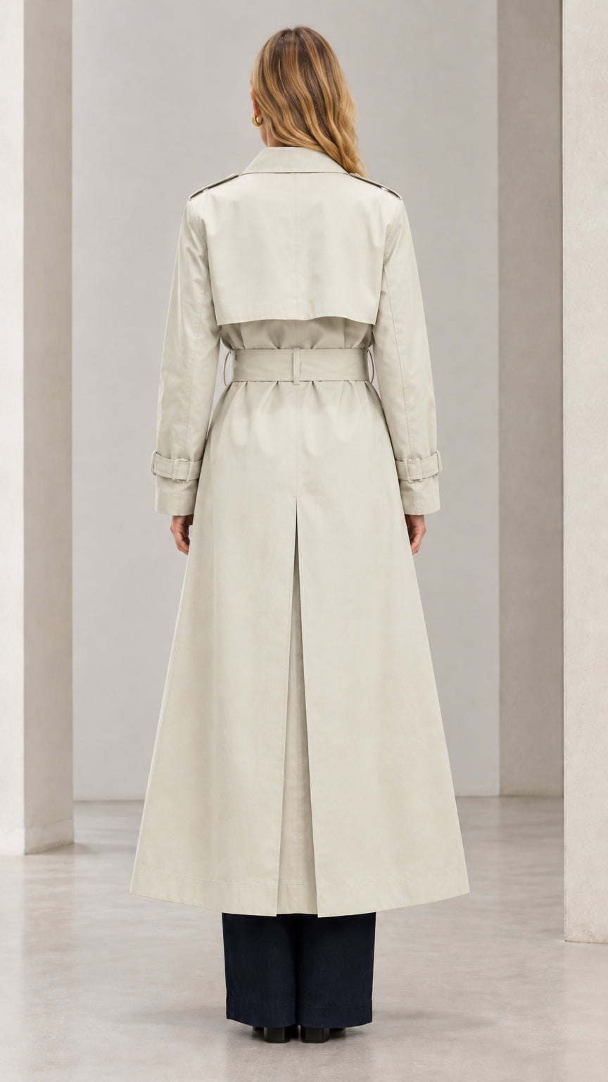 Back view of woman wearing Light Beige maxi trench coat showing back storm flap and vent