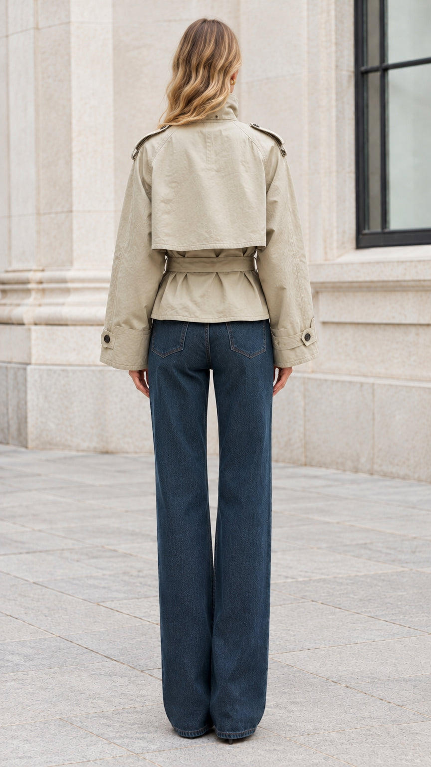 Back view of sage green cropped trench coat displaying storm flap and waist tie