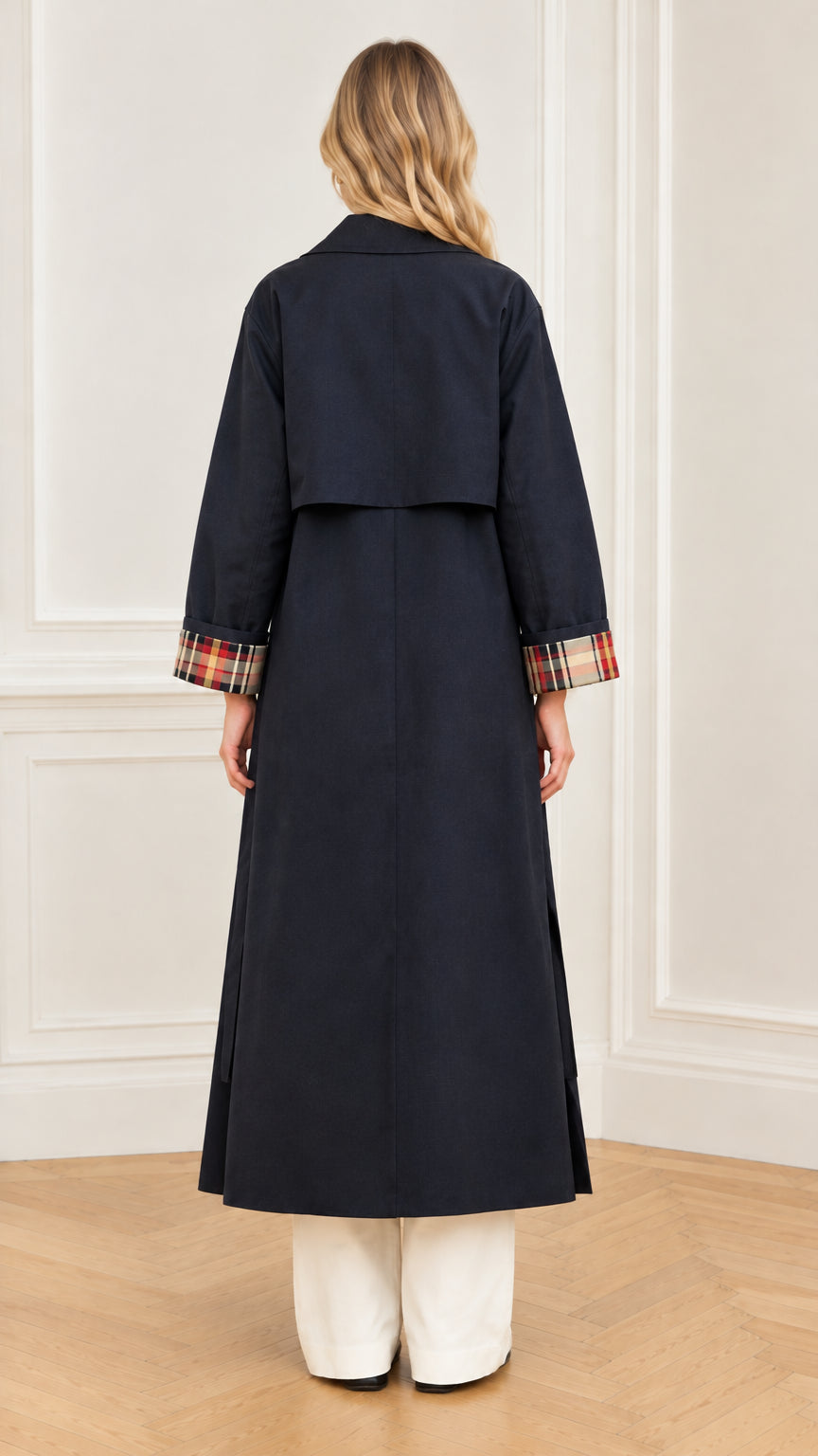 Back view of navy blue longline trench coat showing storm flap construction