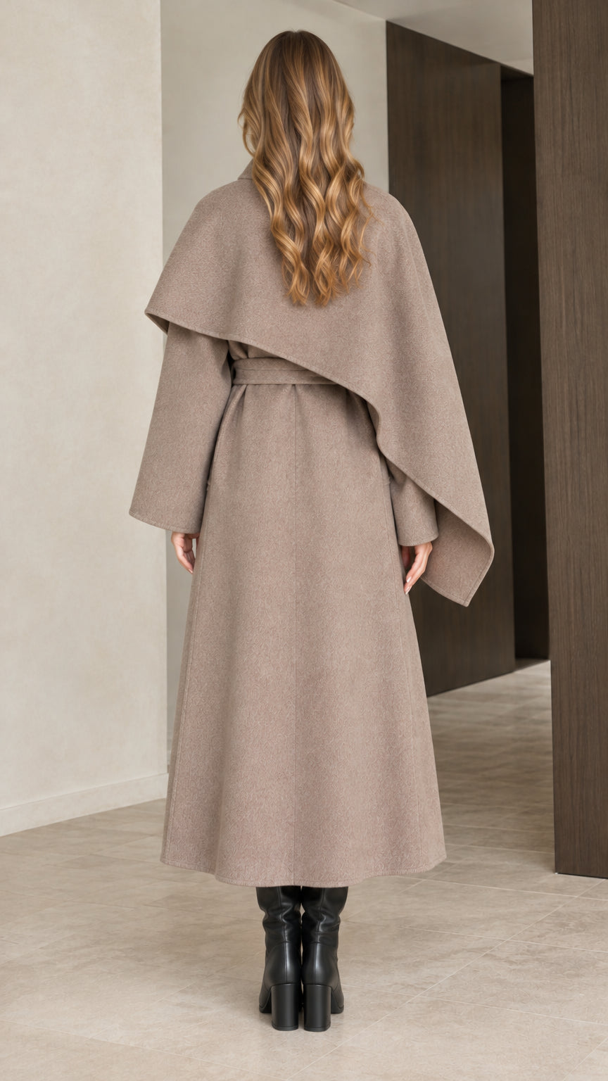 Back view of woman wearing taupe maxi belted coat showing flowing capelet drape