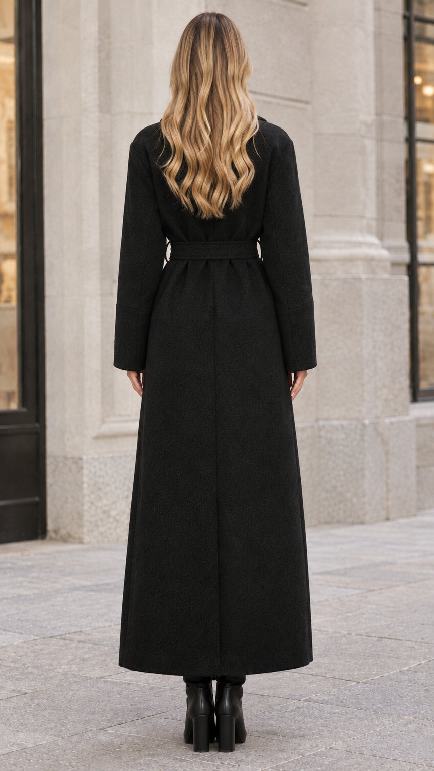Rear view of woman wearing a full-length black trench-style coat