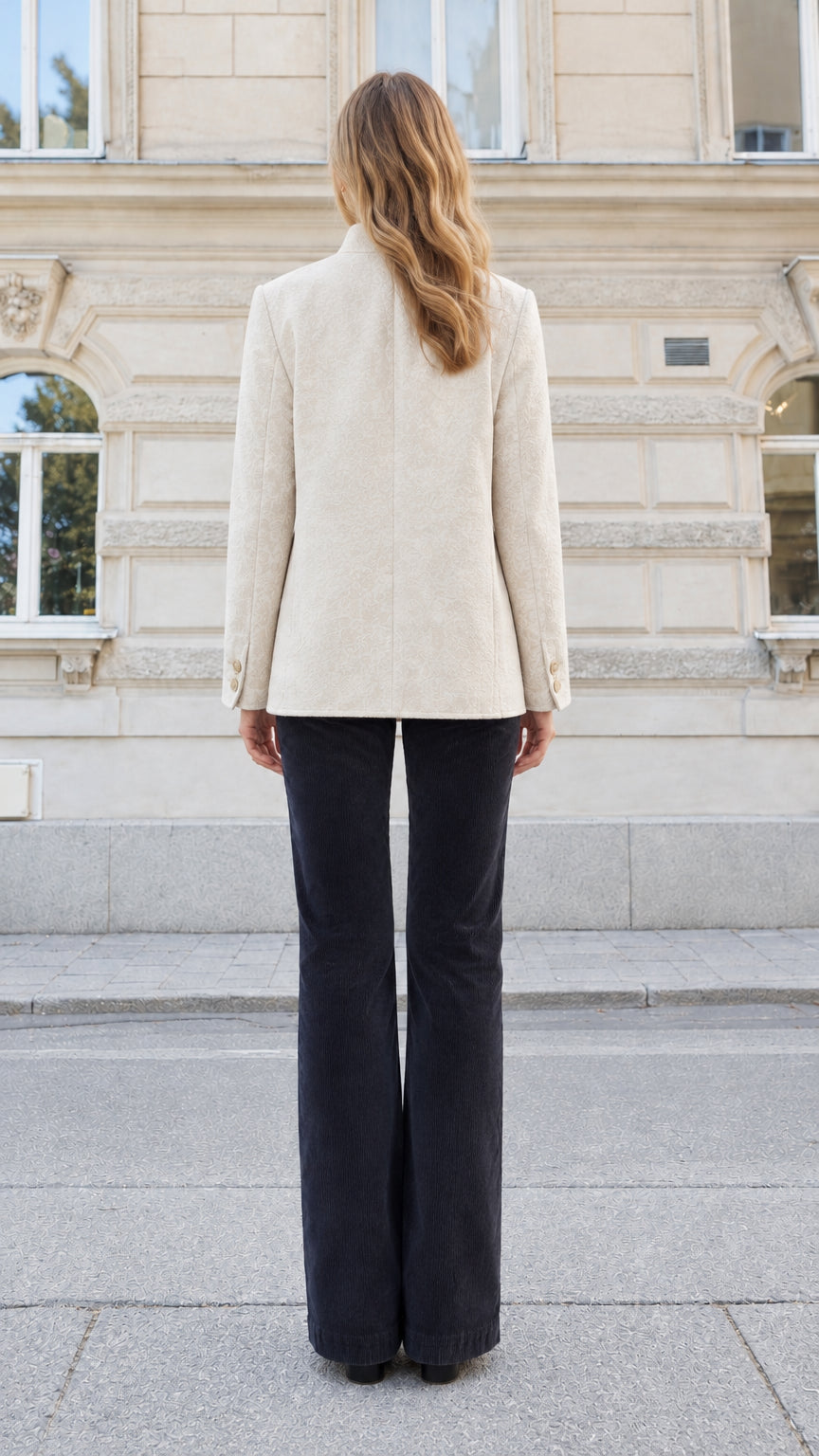 Rear view of a woman wearing a cream tailored stand collar blazer jacket