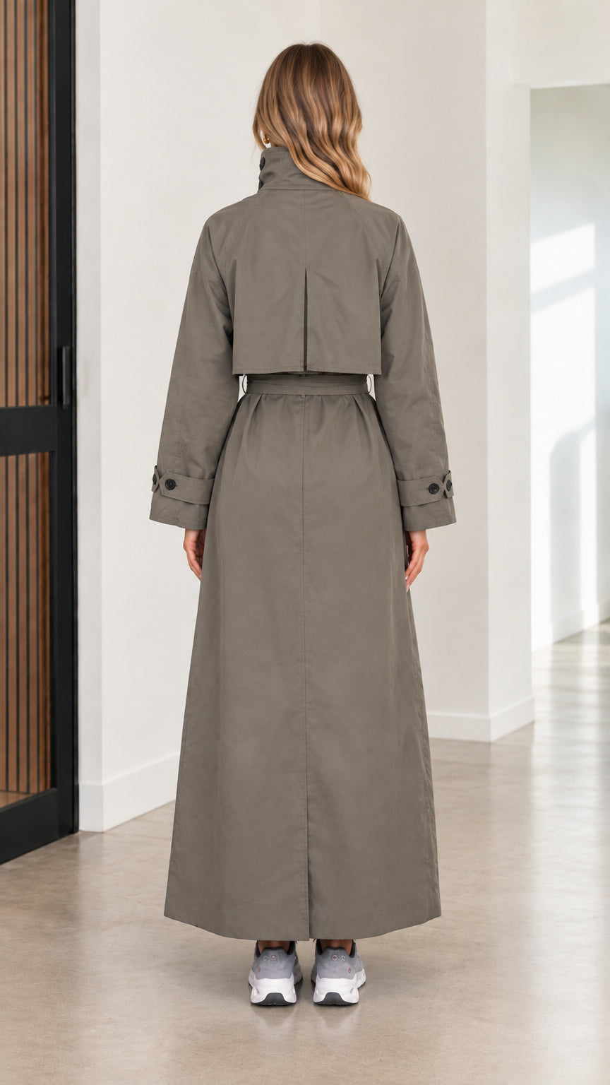 Back view of women's olive green maxi trench coat featuring back storm shield flap