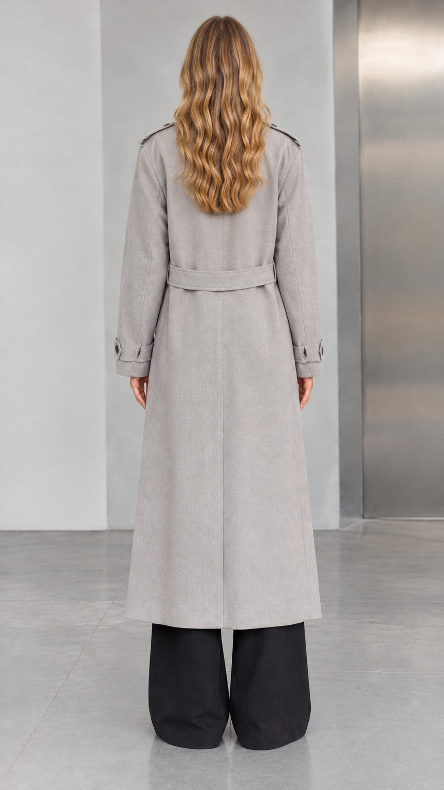 Back view of woman wearing Light Grey longline trench coat featuring back waist belt detail