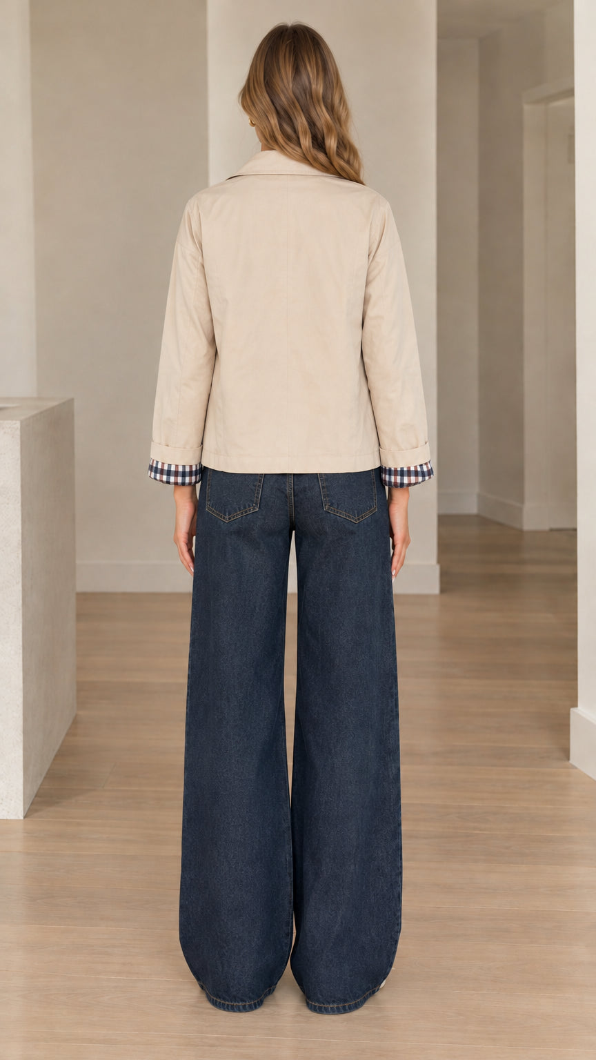 Back view of woman wearing beige short jacket with wide-leg trousers