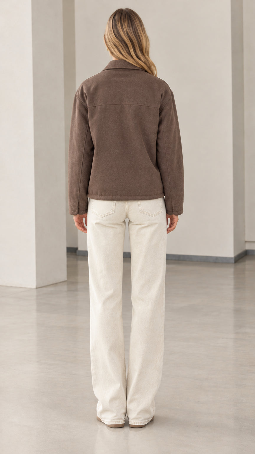 Back full-length view of model showing the clean fit of the brown collared jacket