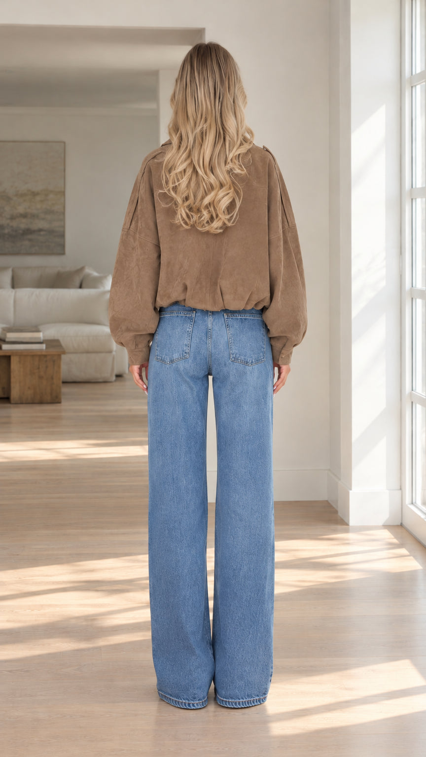 Back view of model wearing brown cropped faux suede bomber jacket