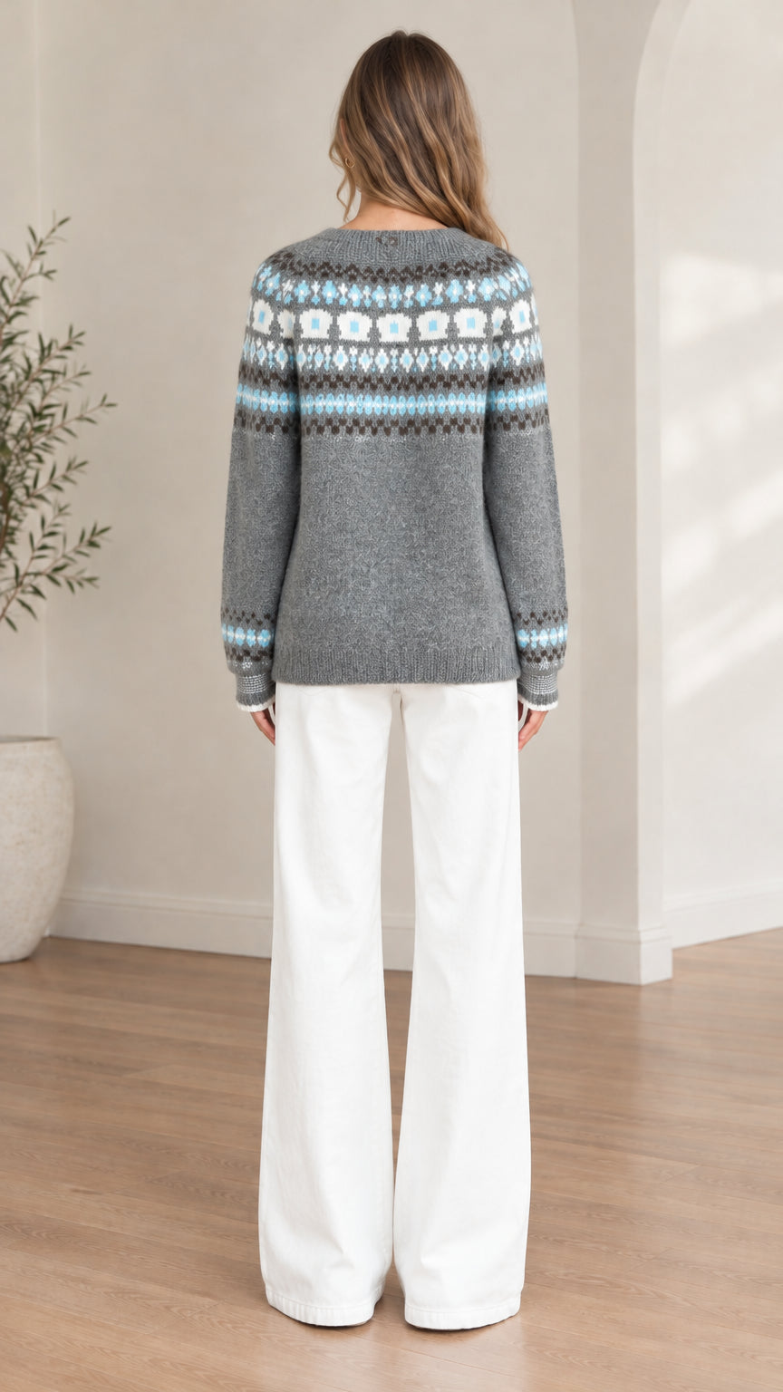 Back view of model wearing a grey Fair Isle patterned knit sweater