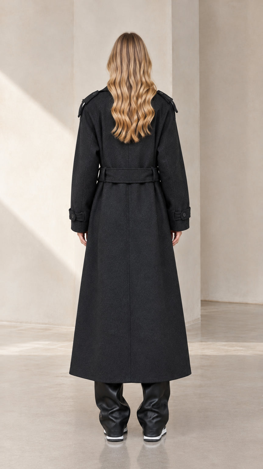 Back full-length view of woman wearing Black belted maxi coat
