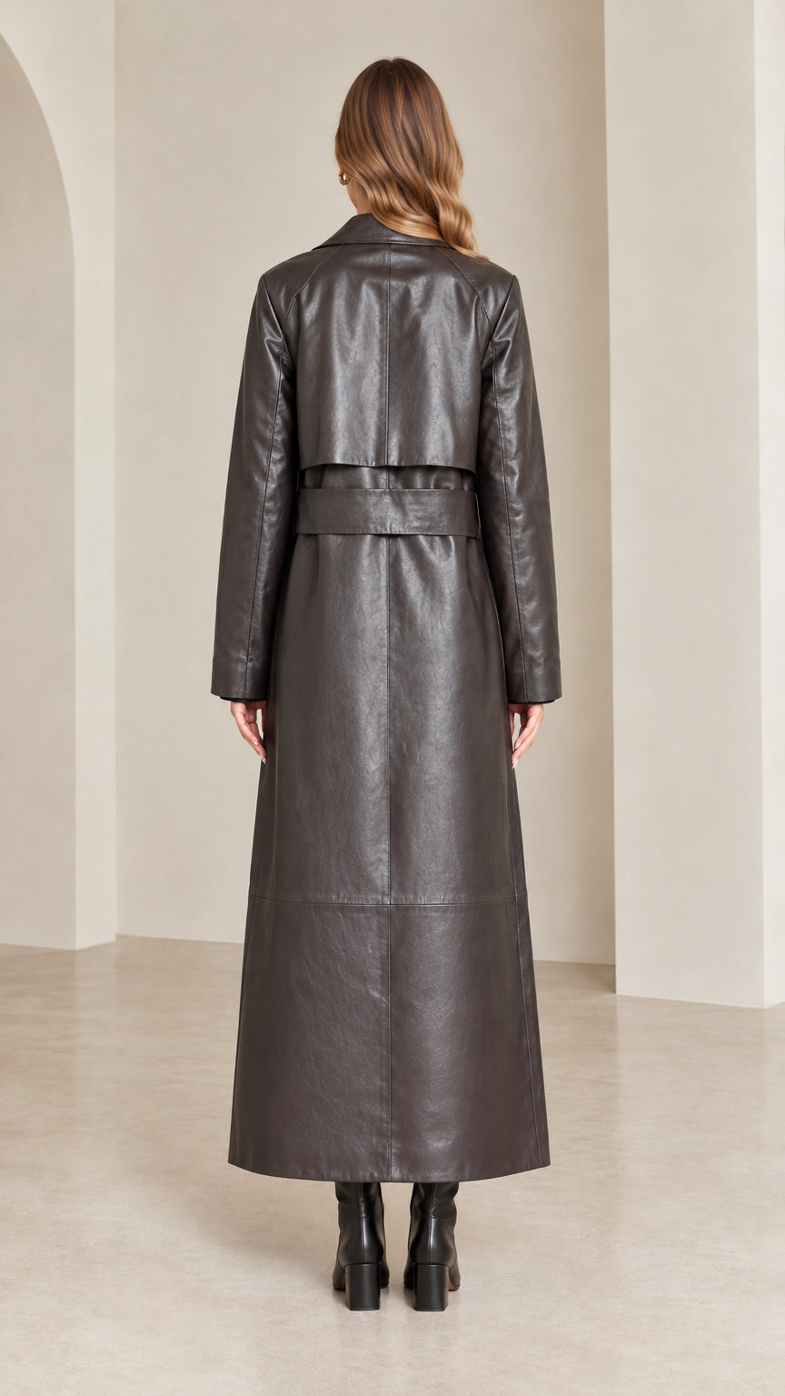 Back view of dark brown maxi trench coat highlighting storm flap and back belt detail