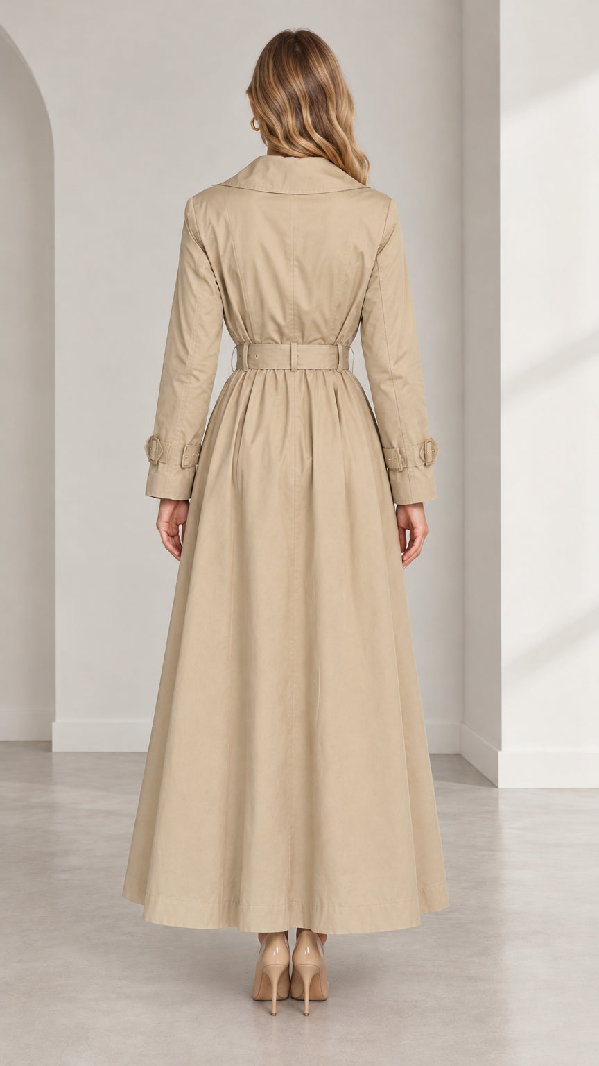 Back view of women's beige long trench coat highlighting tailored back yoke and cinched waist