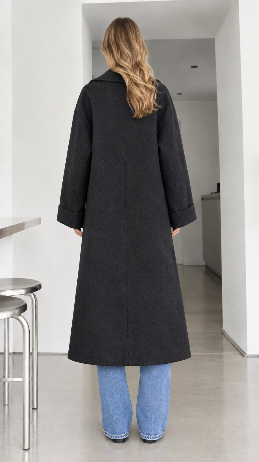 Back full-length view of black maxi overcoat with wide cuffed sleeves