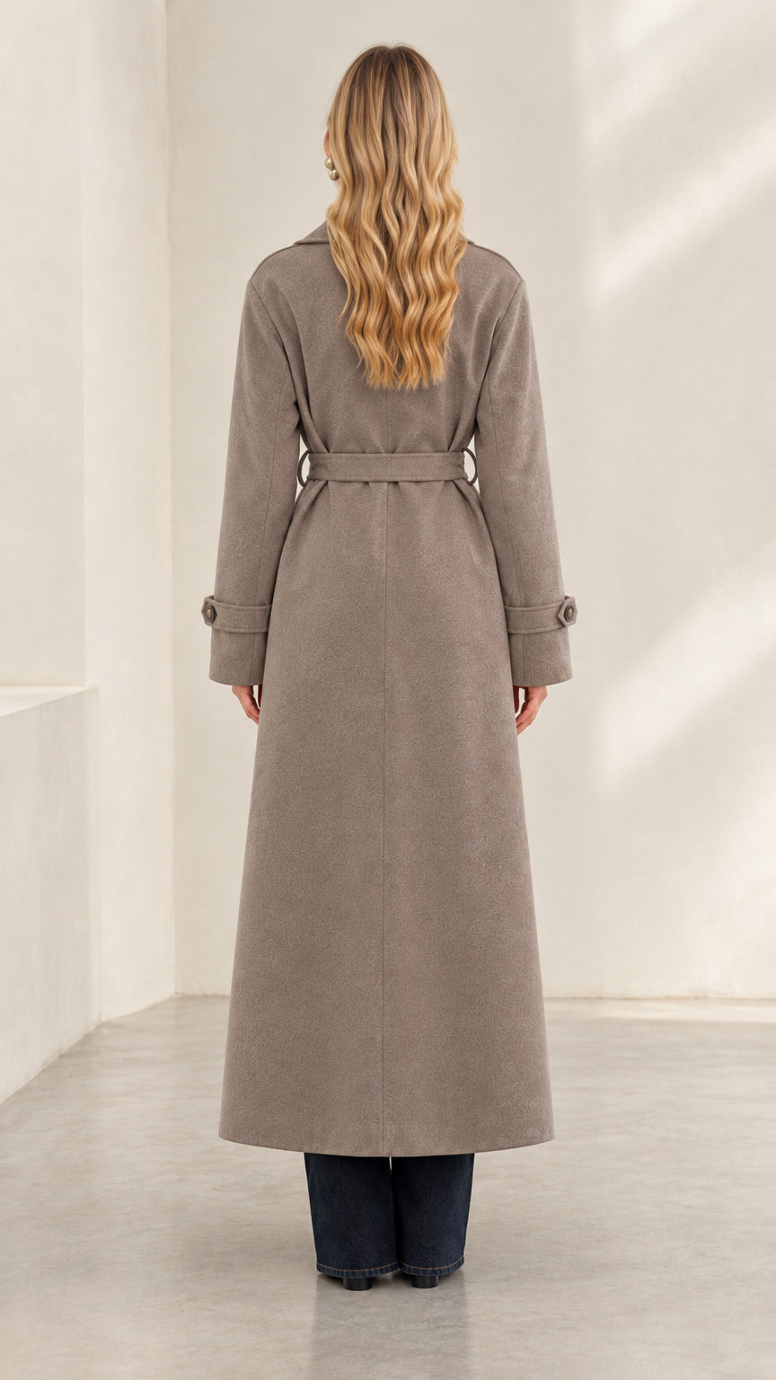 Rear view of woman wearing taupe belted maxi overcoat