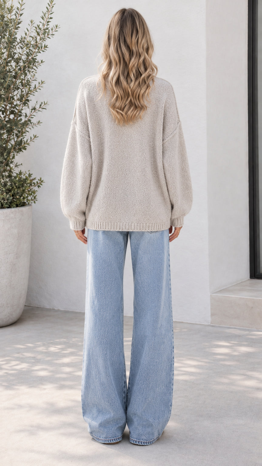 Back view of model wearing oatmeal knit cardigan with drop shoulders