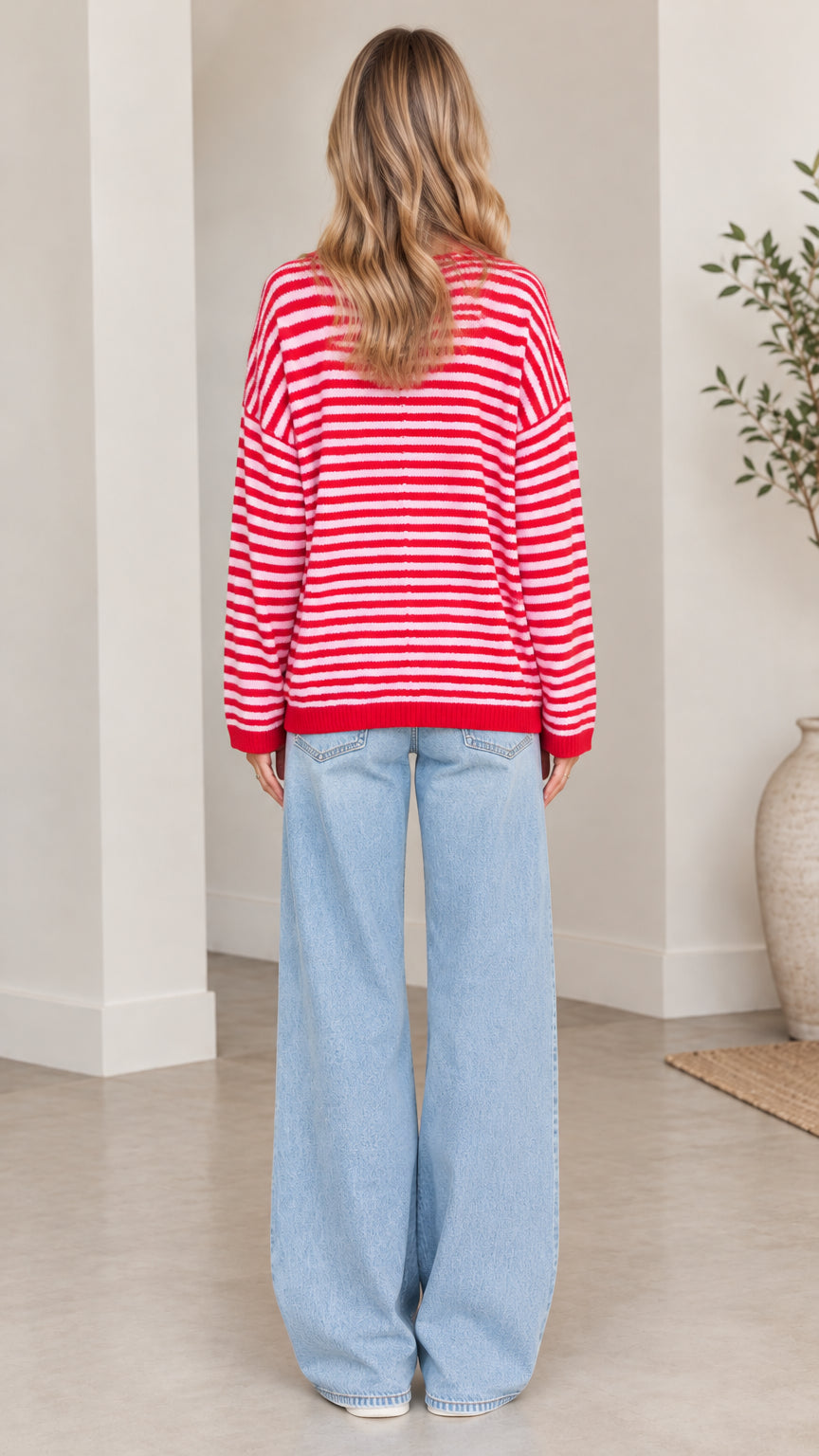 Back full-length view of woman wearing red and white striped collared sweater