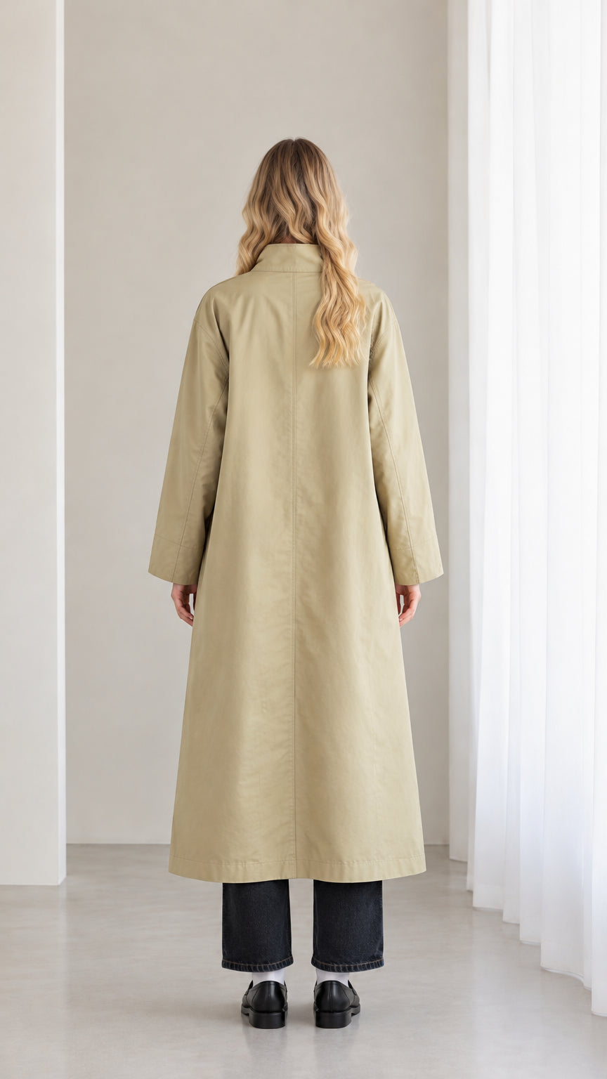 Back full view of woman wearing sage khaki maxi trench overcoat showing center back vent