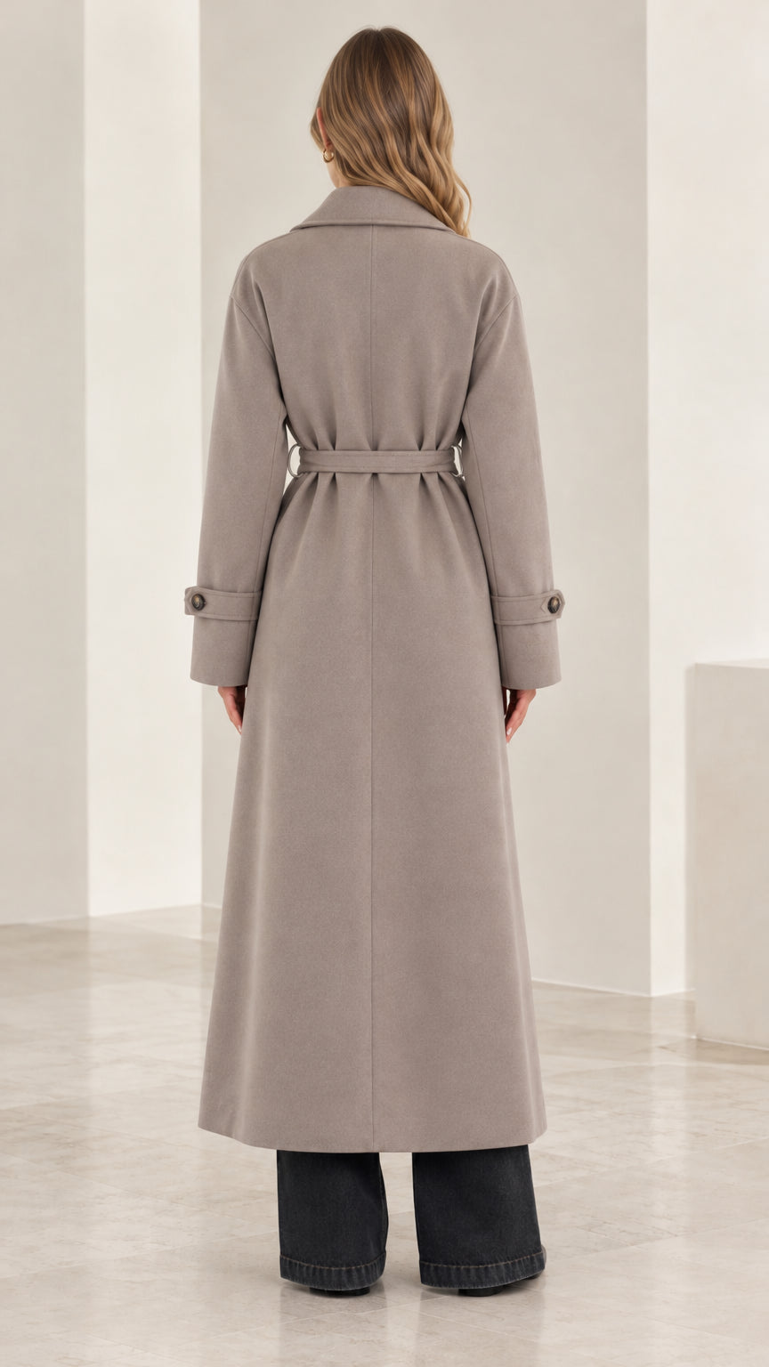 Back view of woman wearing an ankle-length taupe belted trench coat