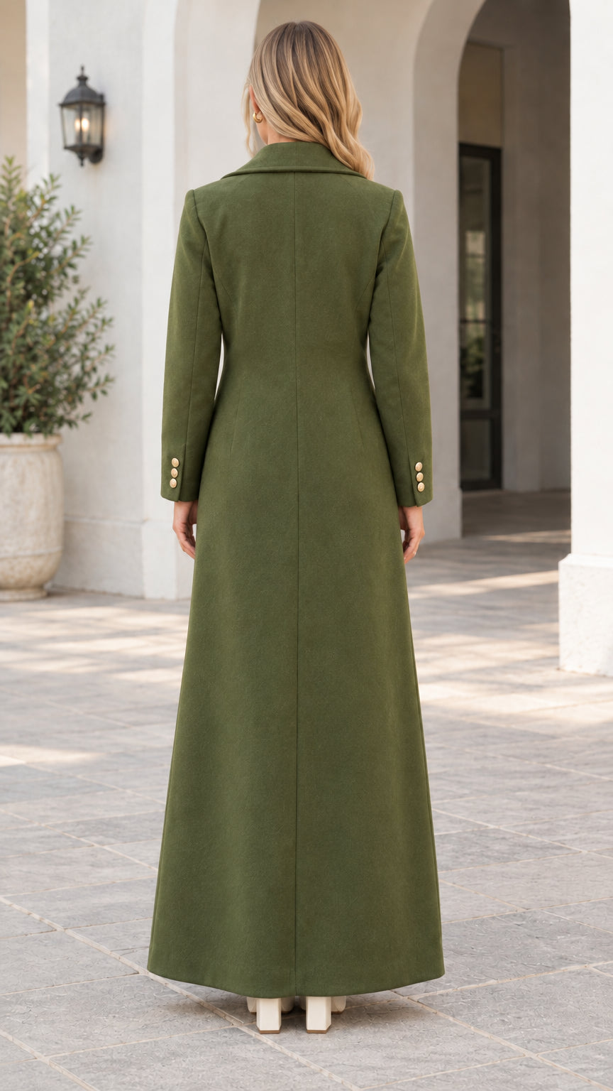 Back full view of woman wearing the olive green maxi coat showing clean tailored back silhouette