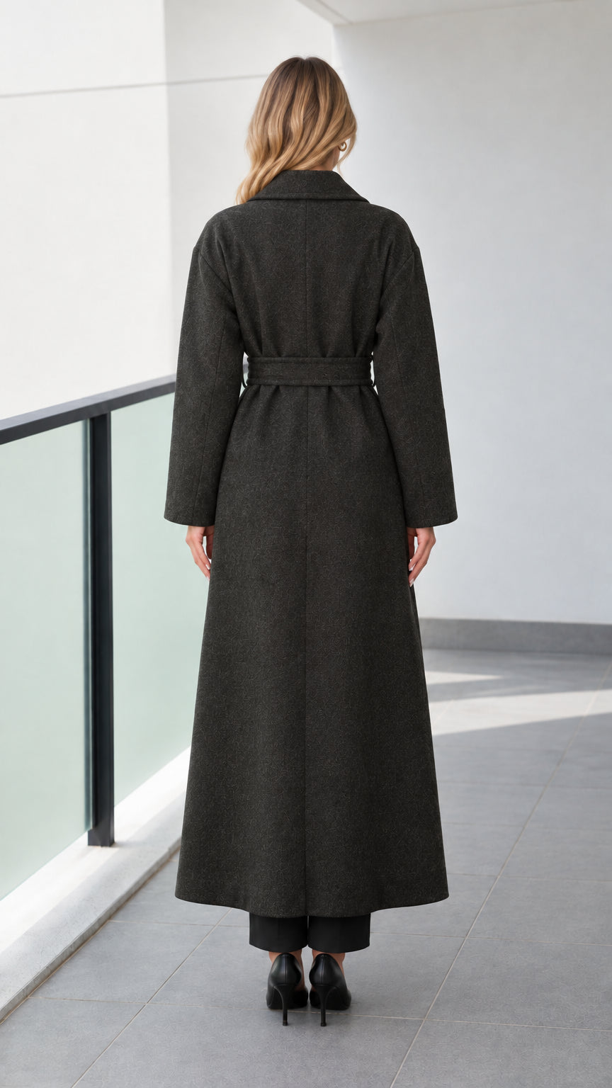 Back view of model wearing a dark grey tailored long wrap coat with belt