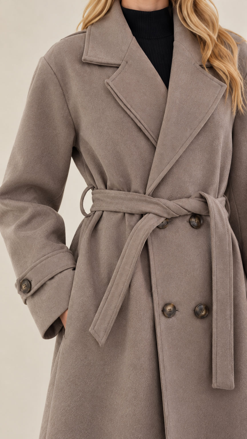 Close-up detail of taupe overcoat notch lapel, double-breasted buttons, and waist belt