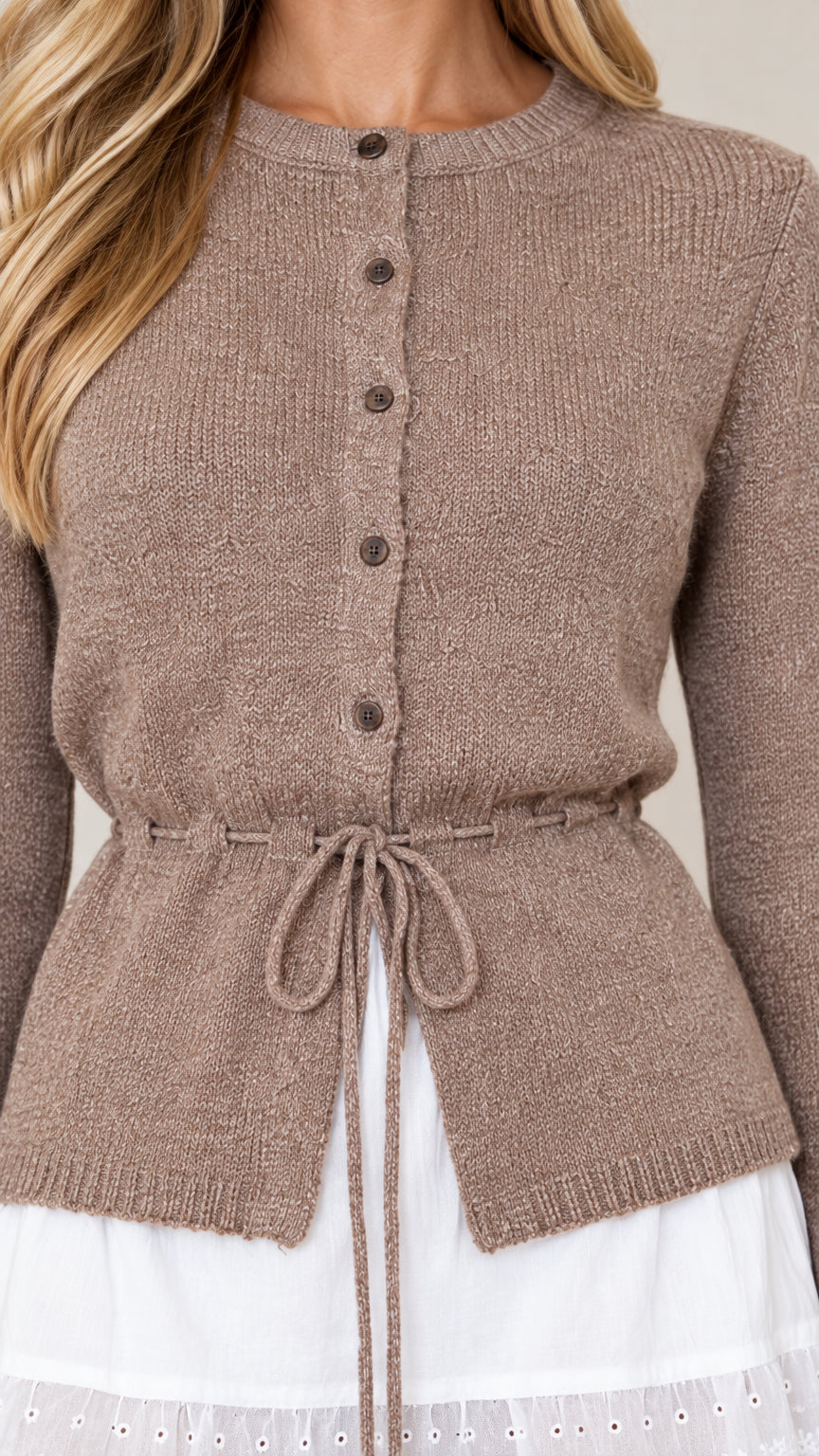 Close-up detail of taupe knit cardigan showing buttons, crewneck, and waist drawstring