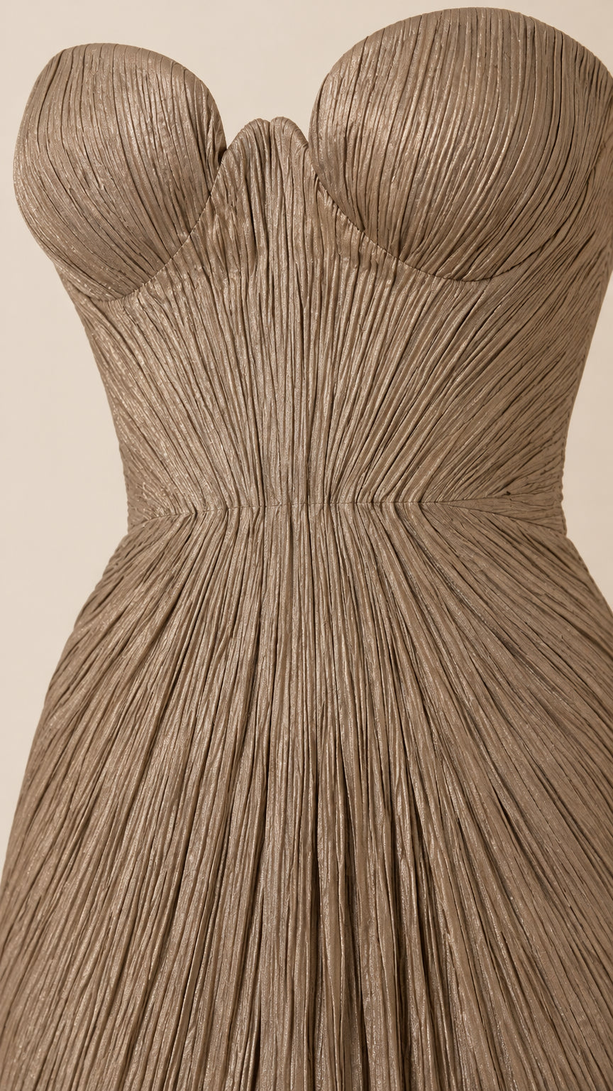 Detailed close-up of champagne plissé fabric texture and structured sweetheart bustier cups