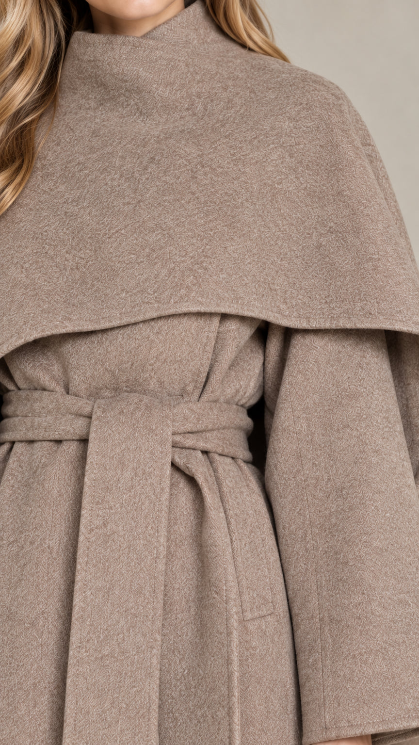 Close-up detail of textured fabric, high funnel collar, and tied belt on taupe coat