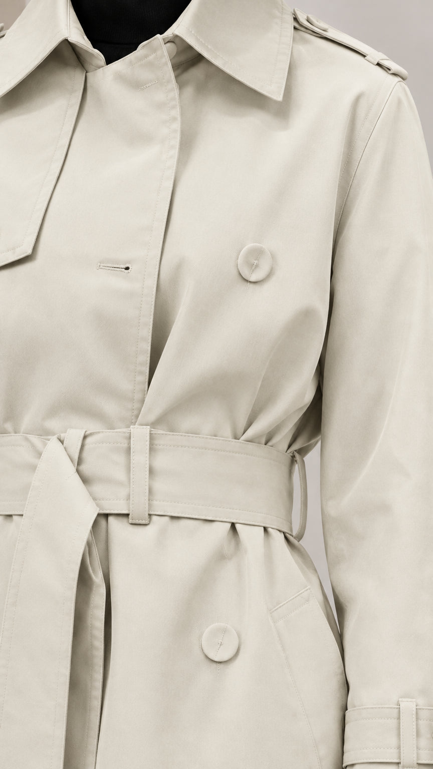 Close-up detail of Light Beige trench coat collar, storm flap, buttons, and belt