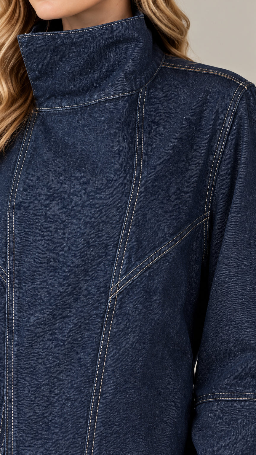 Close-up detail of high stand collar and contrast stitching on dark blue denim fabric